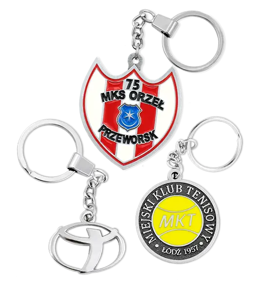 Custom-made keychains: a red and white shield featuring MKS Orzeł Przeworsk and the number 75, a round emblem displaying Miejski Klub Tenisowy Łódź 1957 with a yellow tennis ball, and a stylized metallic car logo.