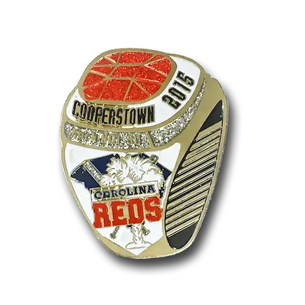 A gold and silver championship ring showcases Cooperstown 2015 with orange and white enamel. Adorned with images of a baseball, palm trees, and Carolina Reds in red and blue, it mirrors the vibrant appeal of soft enamel pins.