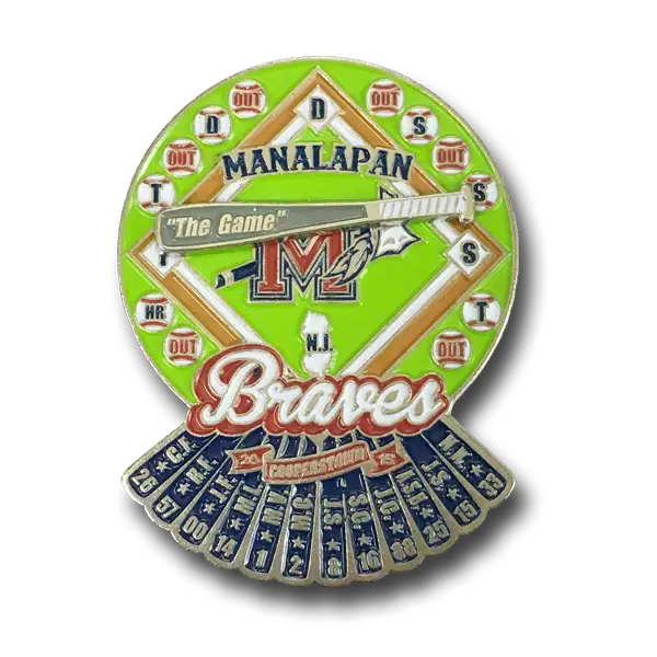A vibrant baseball-themed *soft enamel pin* featuring The Game, Manalapan, and Braves text. It showcases a field layout with marked positions, dates, and events below, complemented by decorative blue elements at the bottom.